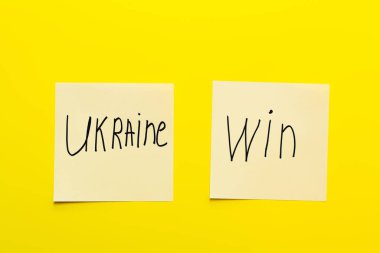 top view of paper cards with ukraine win lettering yellow background clipart