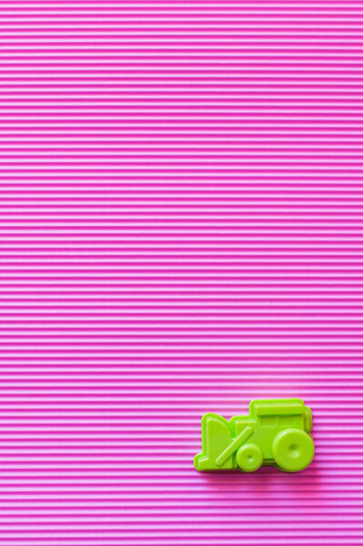 вид сверху на зеленый пластиковый экскаватор на фиолетовом фоне с копировальным пространством