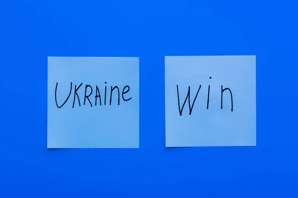 Widok Góry Ukraina Wygrać Liternictwo Kartach Papierowych Niebieskim Tle — Zdjęcie stockowe