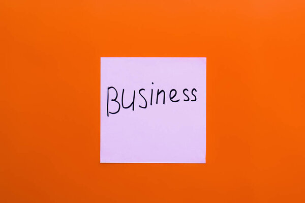 вид сверху на бледно-фиолетовую карточку с бизнес-надписью на красном фоне