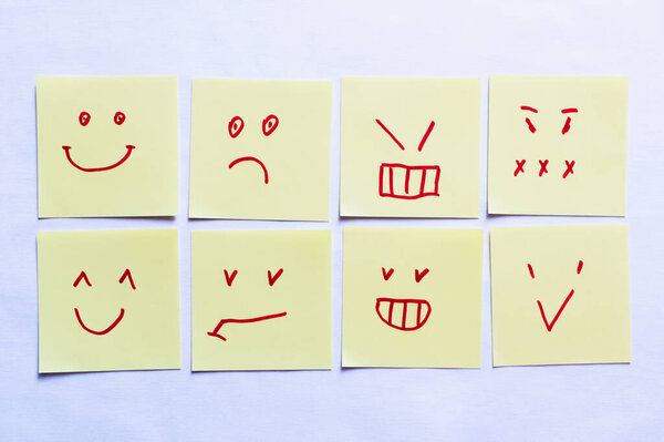 top view of sticky notes with positive and negative smileys on white background