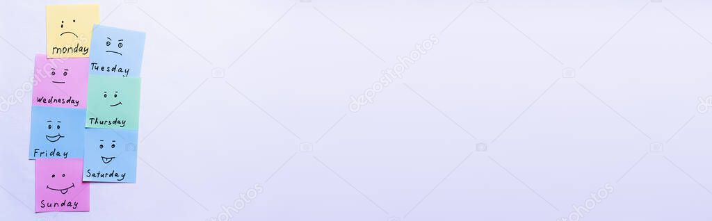 top view of multicolored cards with different emoji and day names on pastel violet background, banner