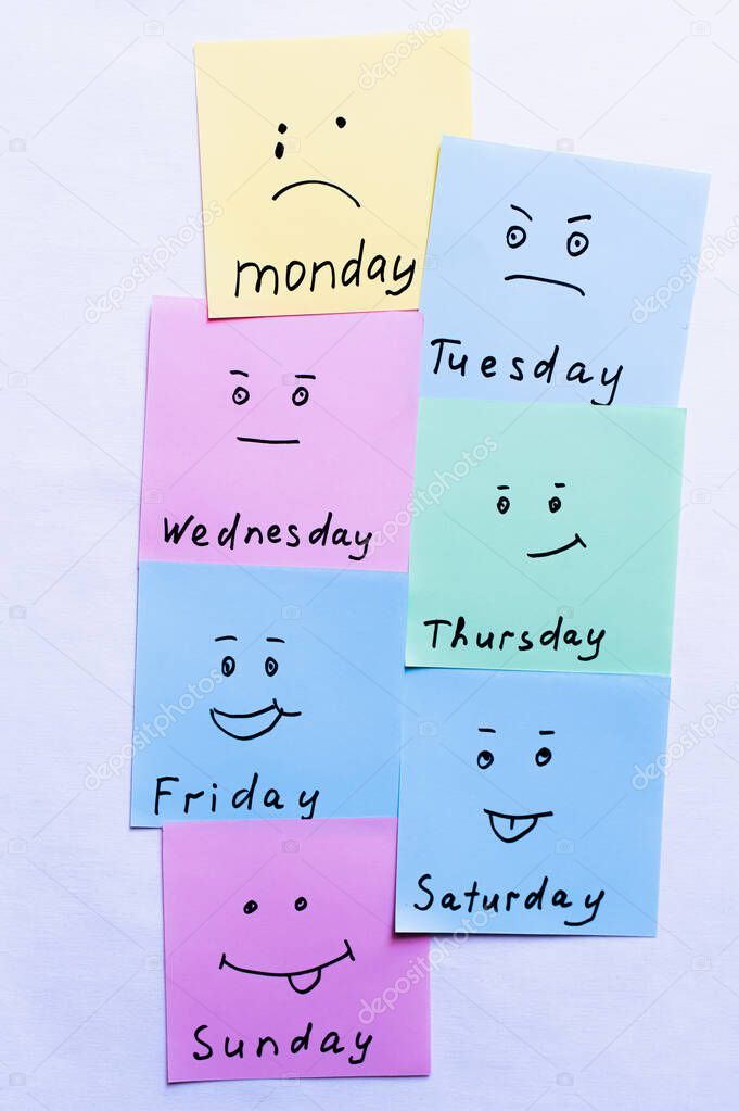 top view of paper notes with day names and smileys with different emotions on white background