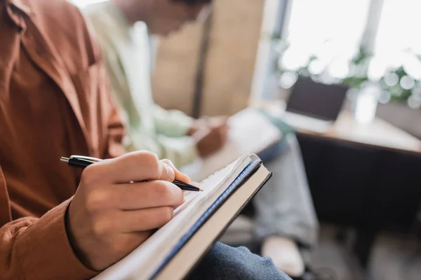 Vista Parcial Escritura Los Estudiantes Cuaderno Sobre Fondo Borroso — Foto de Stock