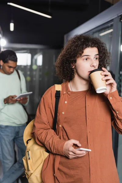 Hombre Rizado Con Teléfono Celular Beber Café Cerca Estudiante Afroamericano —  Fotos de Stock