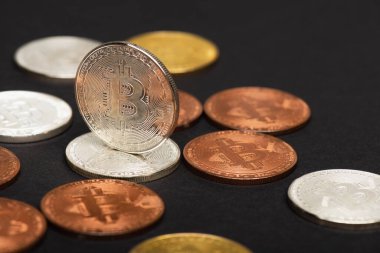 KYIV, UKRAINE - 26 Nisan 2022: Siyah arkaplanda farklı bitcoinlerin görüntüsünü kapat