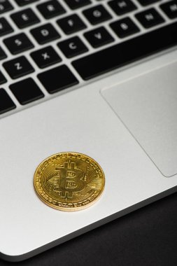 KYIV, UKRAINE - 26 Nisan 2022: Siyah arkaplanda dizüstü bilgisayardaki bitcoin görüntüsünü kapat