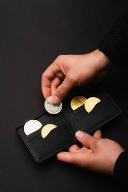 KYIV, UKRAINE - 26 Nisan 2022: Siyah üzerinde bitcoin izole edilmiş cüzdan taşıyan adam görüntüsü 