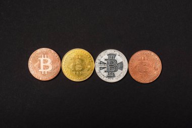KYIV, UKRAINE - 26 Nisan 2022: Siyah üzerinde izole edilmiş farklı bitcoinlerin üst görünümü 