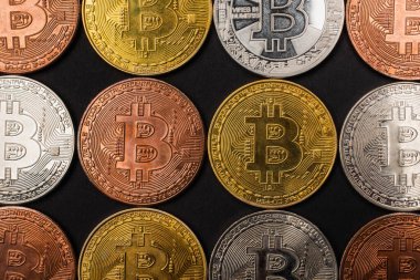 KYIV, UKRAINE - 26 Nisan 2022: Siyah üzerinde izole edilmiş farklı bitcoinlerin üst görünümü 