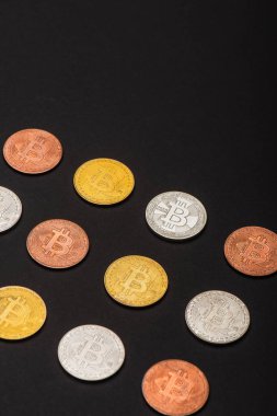 KYIV, UKRAINE - 26 Nisan 2022: Siyah arkaplanda farklı bitcoinlerin yüksek açılı görünümü