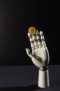 KYIV, UKRAINE - 26 Nisan 2022: Bitcoin ve robotik el siyah arkaplanda