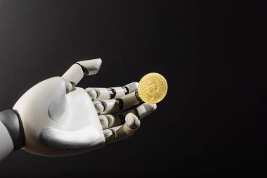 KYIV, UKRAINE - 26 Nisan 2022: Siyah üzerine izole edilmiş robotik elde altın bitcoin 