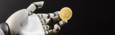 KYIV, UKRAINE - 26 Nisan 2022: Robotik el ve siyah pankarta izole edilmiş altın kripto para 