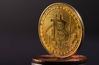 KYIV, UKRAINE - 26 Nisan 2022: Siyah üzerinde izole edilmiş kripto paraların üzerindeki altın bitcoin görüntüsünü kapat 