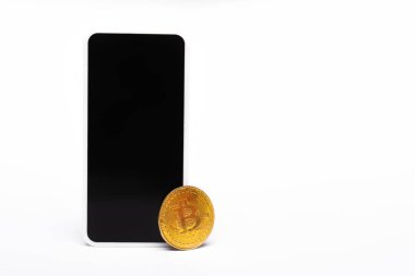 KYIV, UKRAINE - 26 Nisan 2022: Beyaz arkaplanda altın bitcoin yakınında boş ekranlı akıllı telefon 