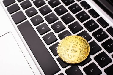 KYIV, UKRAINE - 26 Nisan 2022: Dizüstü bilgisayardaki altın bitcoin görüntüsünü kapat 