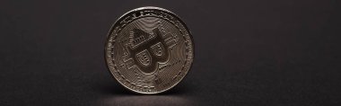 KYIV, UKRAINE - 26 Nisan 2022: Siyah zemin üzerindeki gümüş bitcoin görünümünü kapat, afiş 