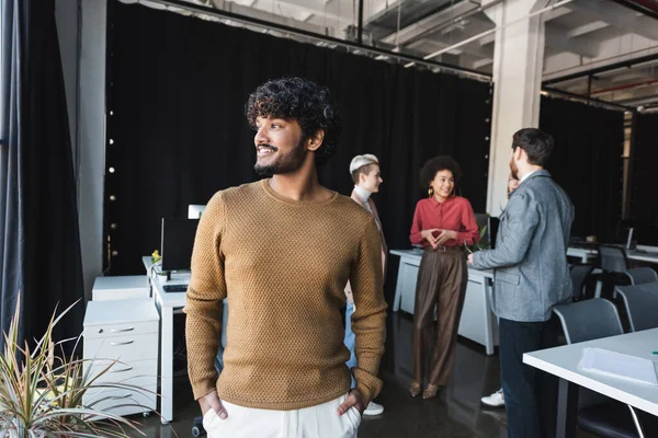 Gelukkig Indisch Zakenman Staan Met Handen Zakken Buurt Interraciale Collega — Stockfoto