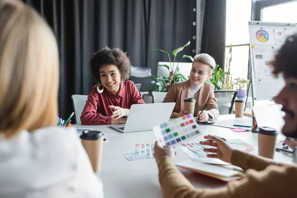 Smiling African American Woman Pointing Hand While Talking Colleagues Advertising — Stock Photo, Image