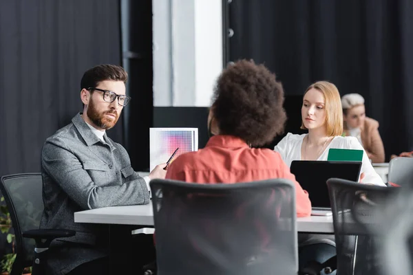 Hombre Barbudo Gafas Apuntando Muestras Color Cerca Diseñadores Publicidad Interracial — Foto de Stock