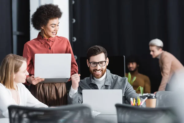 Upphetsad Man Glasögon Visar Framgång Gest Nära Laptop Och Interracial — Stockfoto