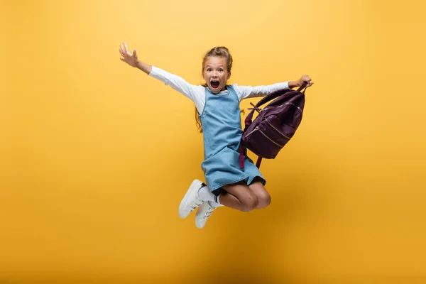 Excited Schoolkid Backpack Jumping Yellow Background — Stock Photo, Image