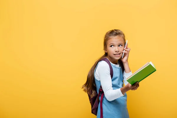 Schülerin Spricht Auf Smartphone Und Hält Buch Isoliert Auf Gelb — Stockfoto