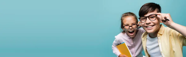 Positieve Multi Etnische Schoolkinderen Brillen Met Notitieboekjes Pennen Geïsoleerd Blauw — Stockfoto