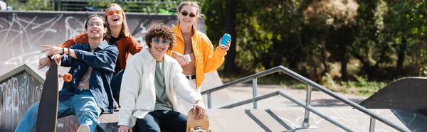 快乐而时尚的多文化滑雪者在滑板公园看着相机 — 图库照片