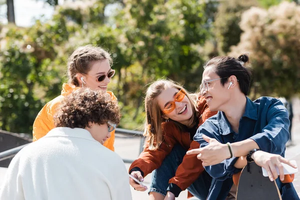 Alegre Asiático Hombre Apuntando Con Dedo Cerca Joven Con Estilo — Foto de Stock