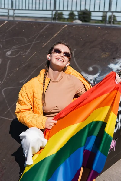 Щаслива Жінка Бездротових Навушниках Сидить Прапором Lgbt Рампі Скейт Парку — стокове фото