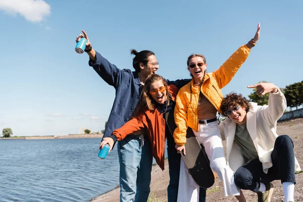 Homme Heureux Montrant Signe Roche Près Amis Multiculturels Avec Skateboard — Photo