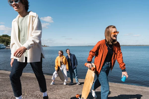 Smiling Woman Walking Riverside Longboard Soda Can Interracial Friends — Stock Photo, Image