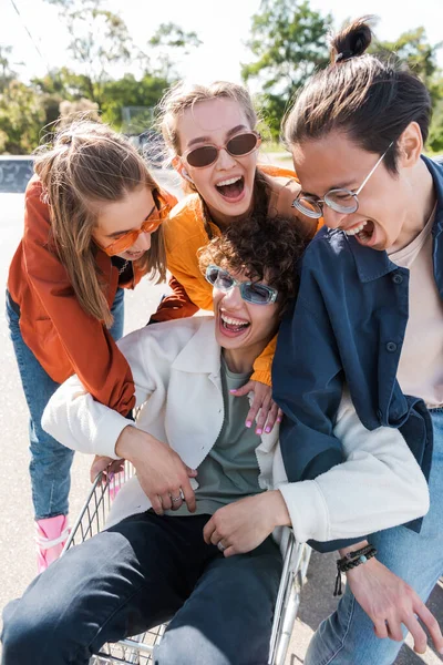 Multiethnic Friends Laughing Man Sitting Shopping Trolley — Stock Photo, Image