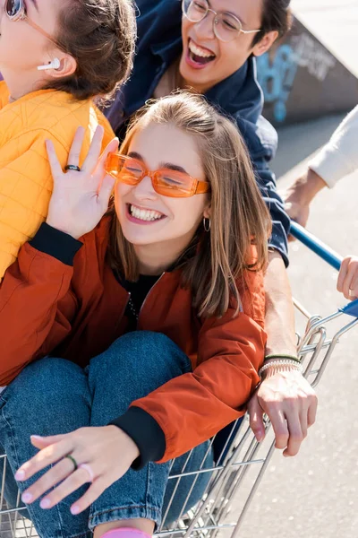 Happy Woman Closed Eyes Adjusting Sunglasses While Sitting Shopping Cart — Stock Photo, Image
