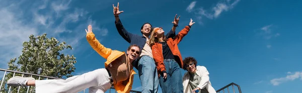 Vista Ángulo Bajo Alegres Amigos Multiétnicos Posando Contra Cielo Azul — Foto de Stock