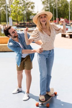 Gündüz vakti kaykay parkında sörf yapan neşeli bir çift. 