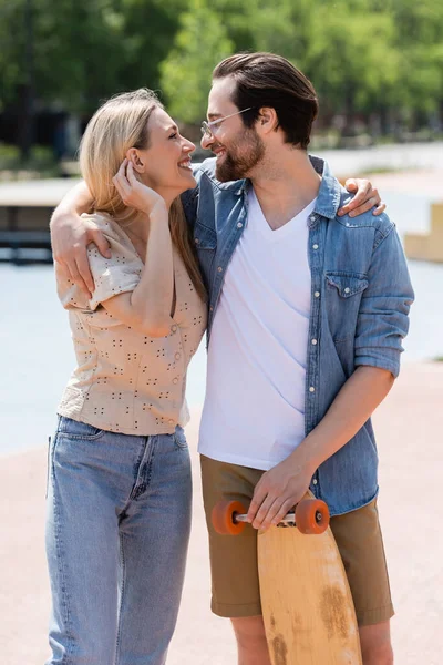 Kaykay parkında kucaklaşan çift yan görünümü 