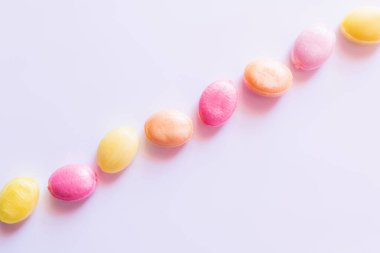 Beyaz arkaplanda renkli şekerlemeler ile düz yatıyordu 