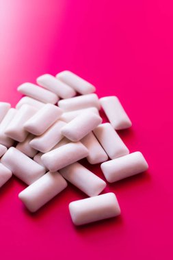 Pembe arka planda beyaz sakız çiğneme görüntüsünü kapat 