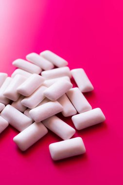 Close up view of white chewing gums on pink background  clipart