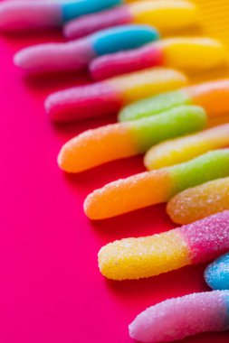 Close up view of jelly sweets in sugar on pink and yellow surface  clipart