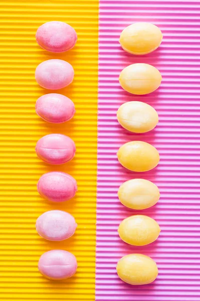 浅黄色和粉红色的背景上有棒棒糖 — 图库照片