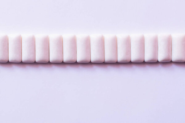 Плоский лежал в ряд от жевания десен на белом фоне 