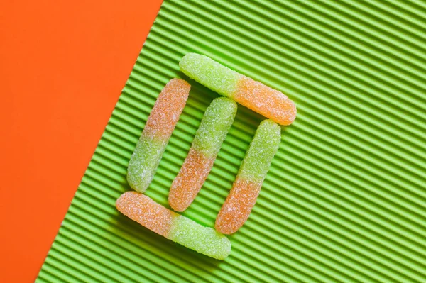 Плоская Лежа Вкусными Желейными Сладостями Текстурированной Зеленой Оранжевой Поверхности — стоковое фото