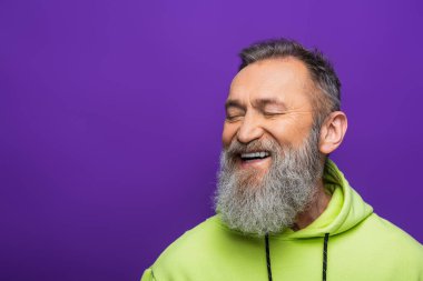 Sakallı, gri saçlı, gözleri mora kapalı gülümseyen neşeli yaşlı adam. 