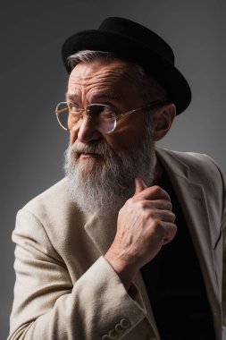 Bej ceketli, şapkalı, gri şapkalı şık bir son sınıf öğrencisiyim.