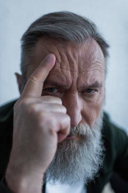 Hüzünlü yaşlı adamın portresi kırışıklıklara ve acı çeken krize dokunuyor. 