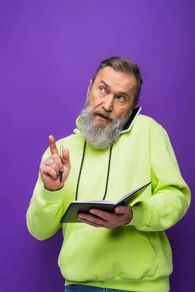 Homem Sênior Com Capuz Verde Segurando Caneta Notebook Enquanto Fala — Fotografia de Stock